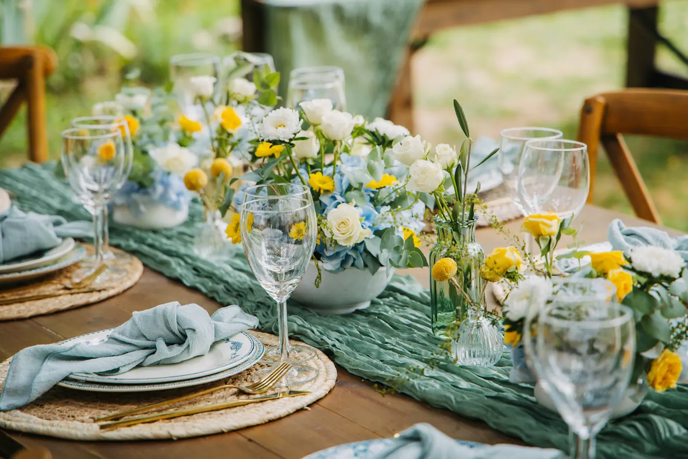 Table with yellow and white flowers and blue napkins