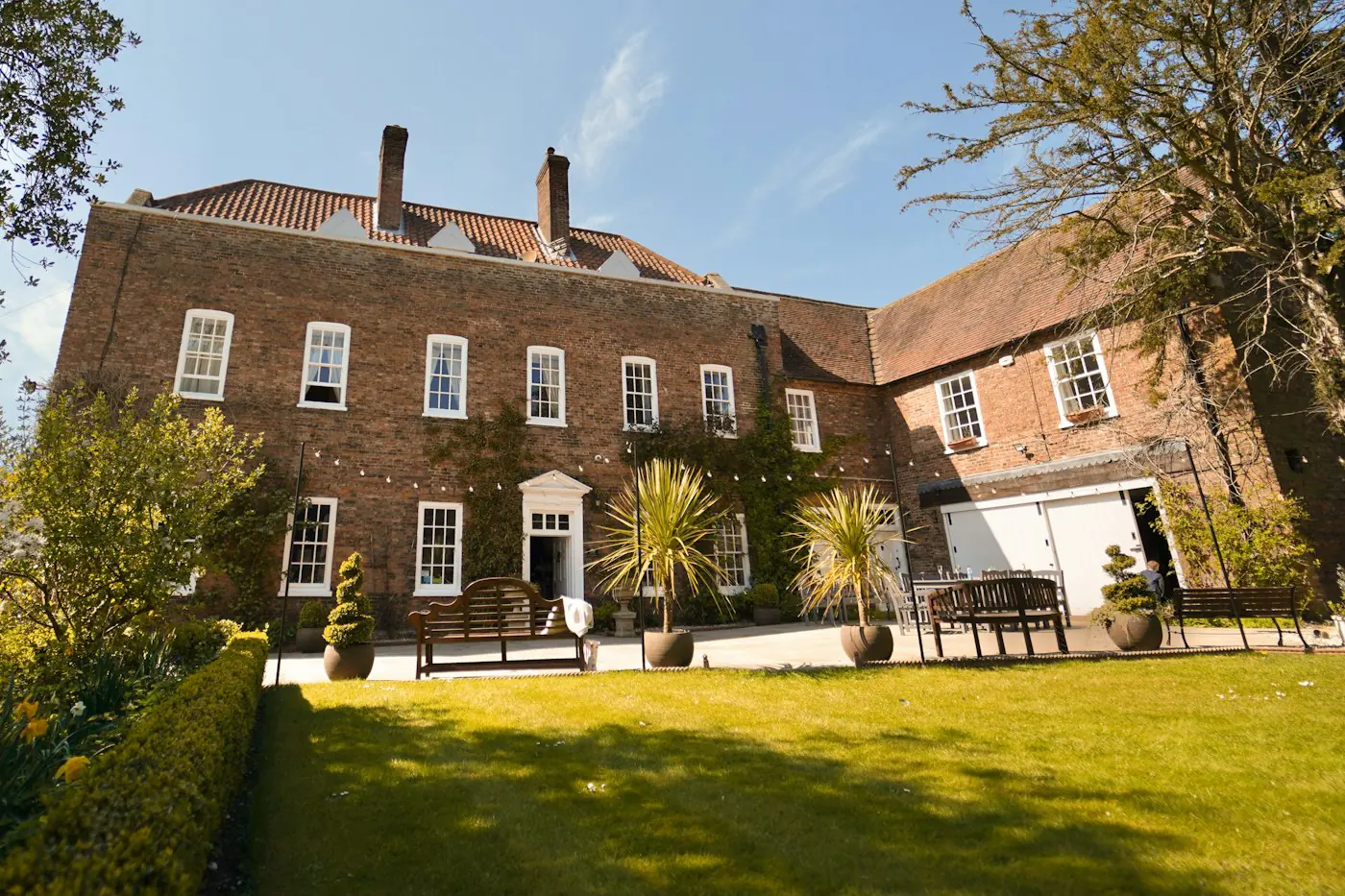 Red-brick country house on a sunny lawn