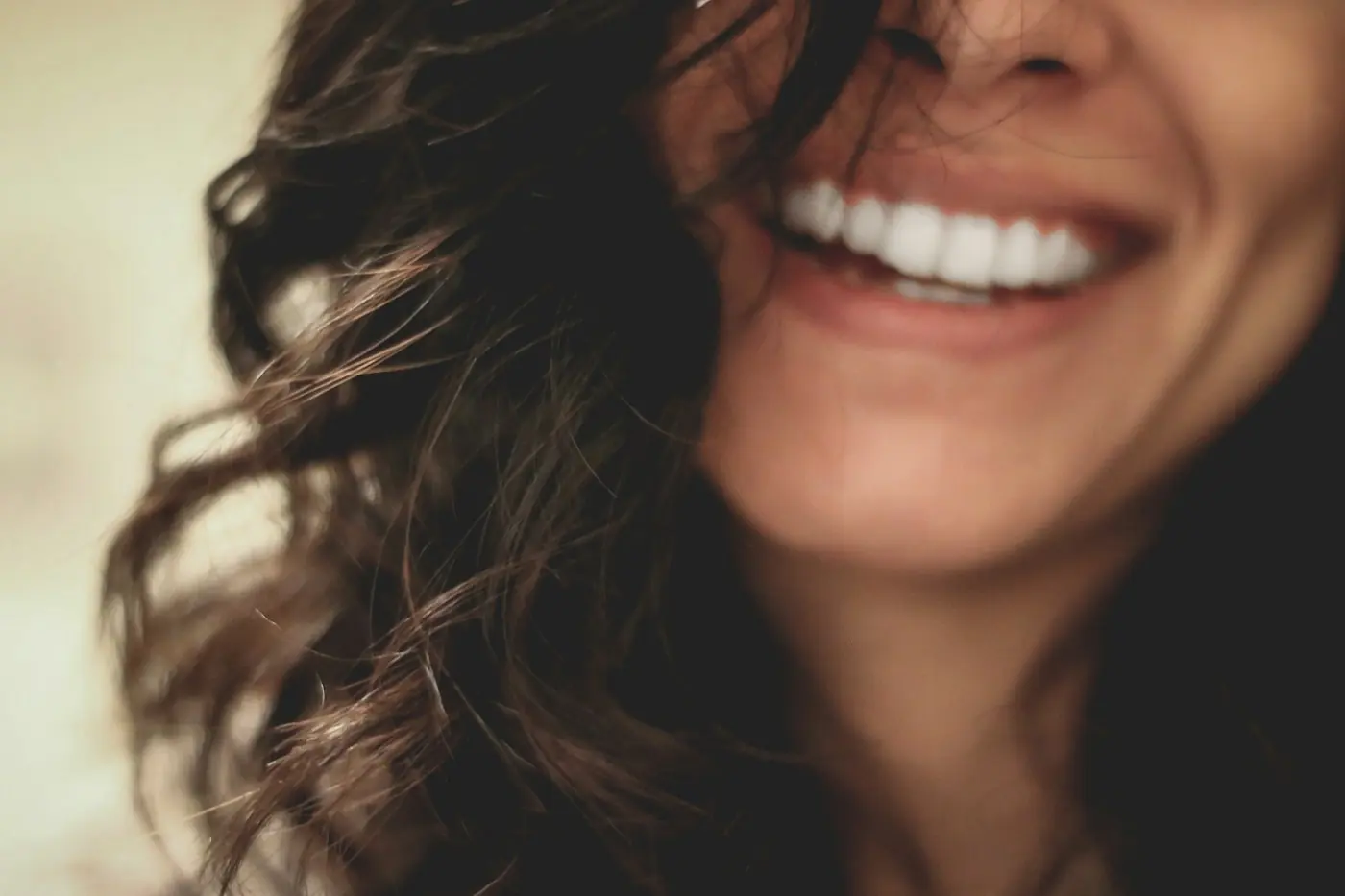 Woman with curly hair smiling broadly